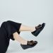 woman in black pants wearing black leather peep toe heeled shoes