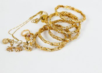 gold chain necklace on white surface