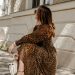 woman in brown and black leopard print dress holding white leather handbag