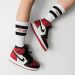 person wearing pair of black toe Air Jordan 1's