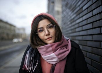 woman in black coat wearing red scarf and black framed eyeglasses