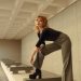 a woman in black shirt and pants standing on a bench