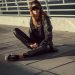 woman in black leather jacket and black pants sitting on floor
