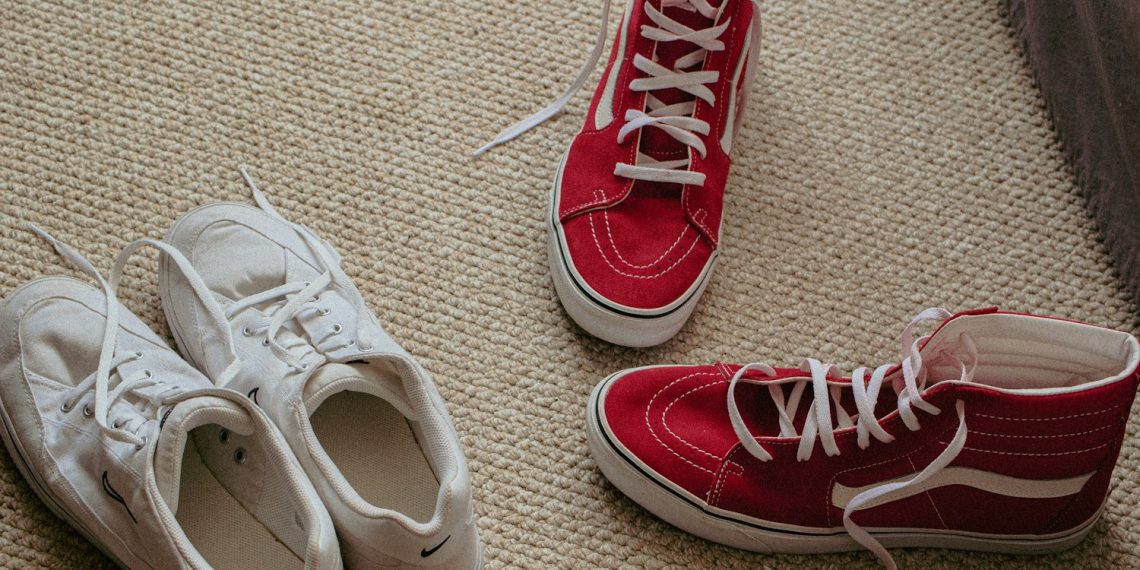 a pair of red and white tennis shoes on the floor