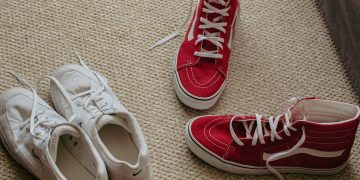 a pair of red and white tennis shoes on the floor